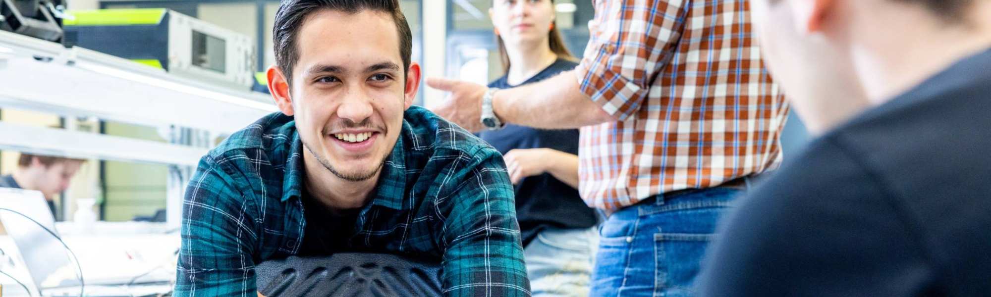 Embedded systems engineering student Lorenzo zit op het soldeerplein.