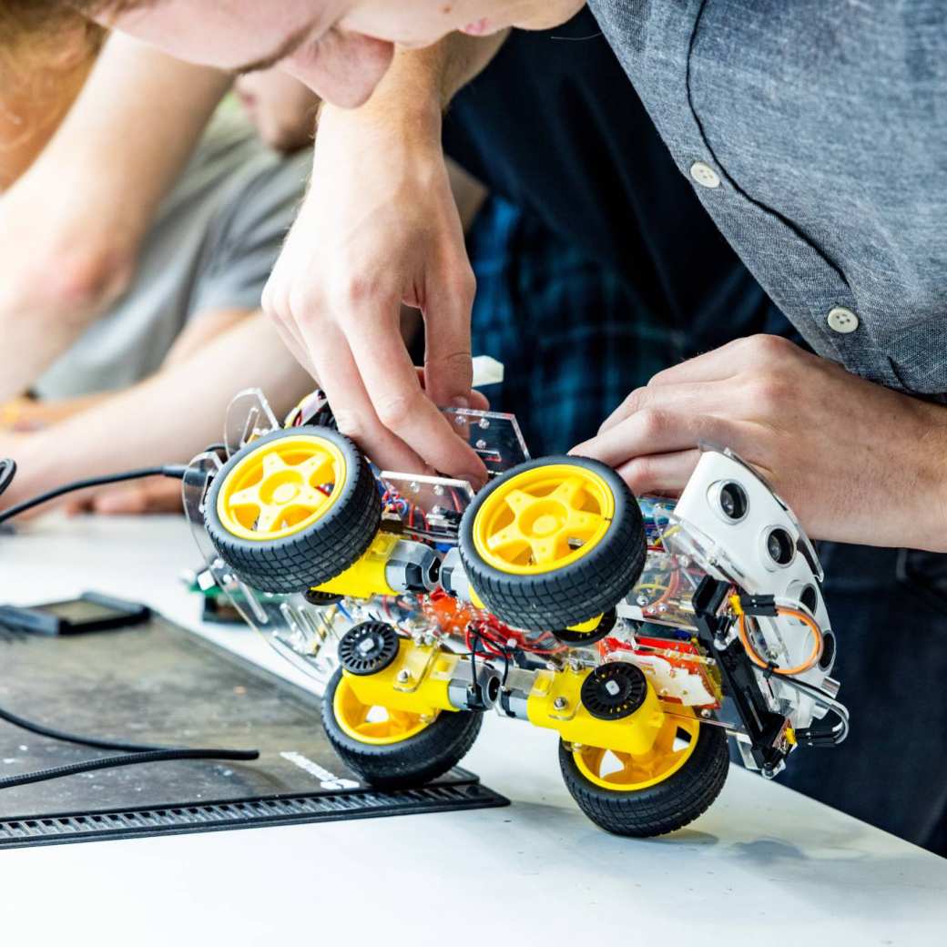 Student Marlo van embedded systems engineering werkt aan een programmeerbare auto.